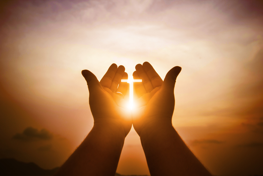 Person's Hands with Cross Silhouette and Sunlight